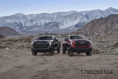 Pack shot of the 2027 GMC Sierra HD Denali Ultimate and AT4X (from left to right), positioned off-road. Preproduction model shown. Actual production model may vary.